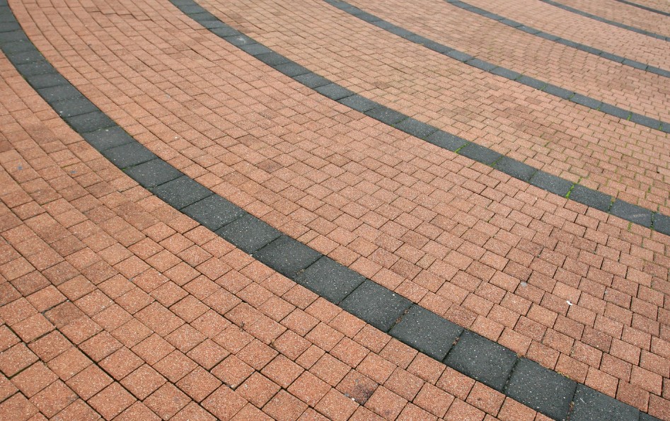 Pavimento de adoquín de hormigón impreso bicolor con cenefas en plaza peatonal — Toledo