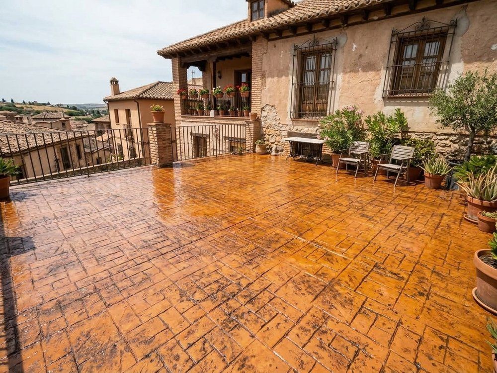 Patio de vivienda en Talavera de la Reina con hormigón impreso recién resellado en tono terracota